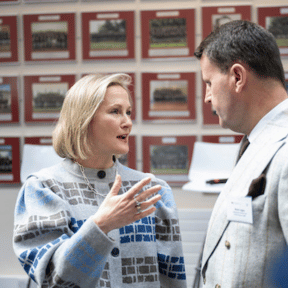 two established graduates chatting one male one female