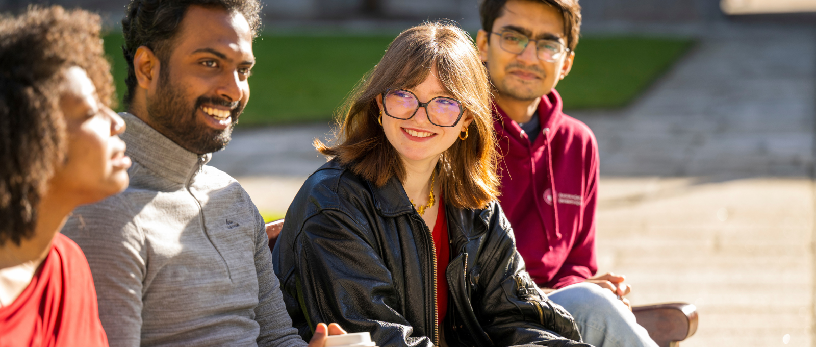 Postgraduate students talk together in a casual outdoor setting in the Quadrangle, University of Galway