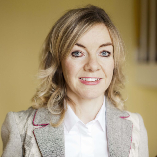 An tOllamh Ri&oacute;na N&iacute; Fhrighil [Ar Thr&eacute;imhse Shab&oacute;ideach Thaighde, 2026-2027]
