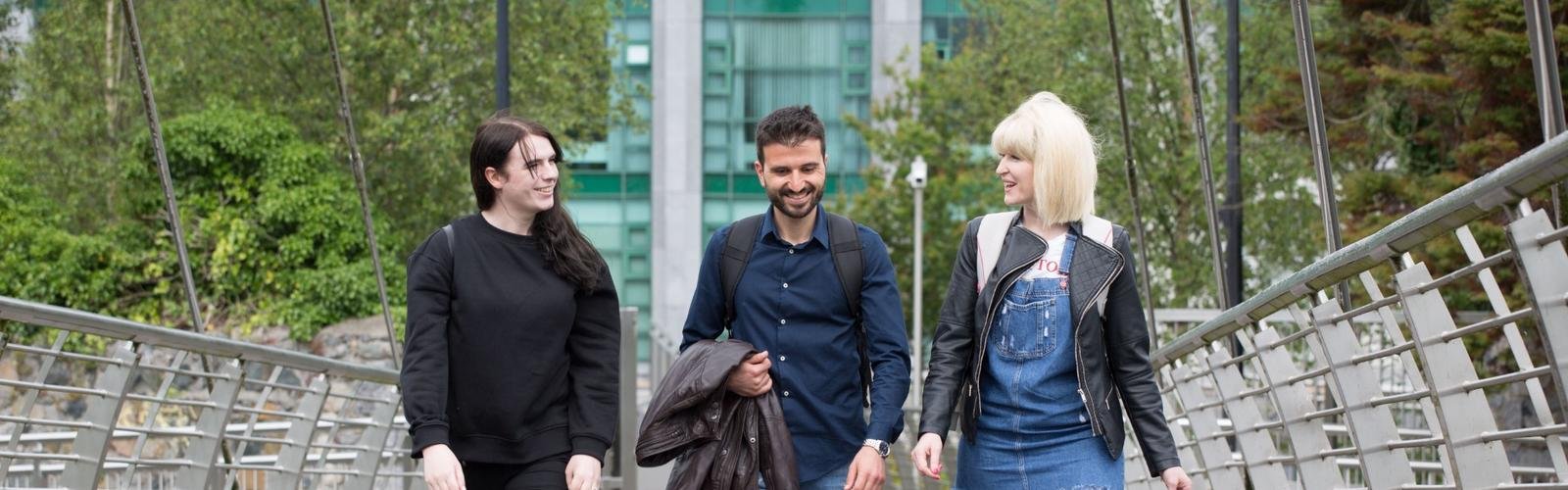 Three students walking together and smiling