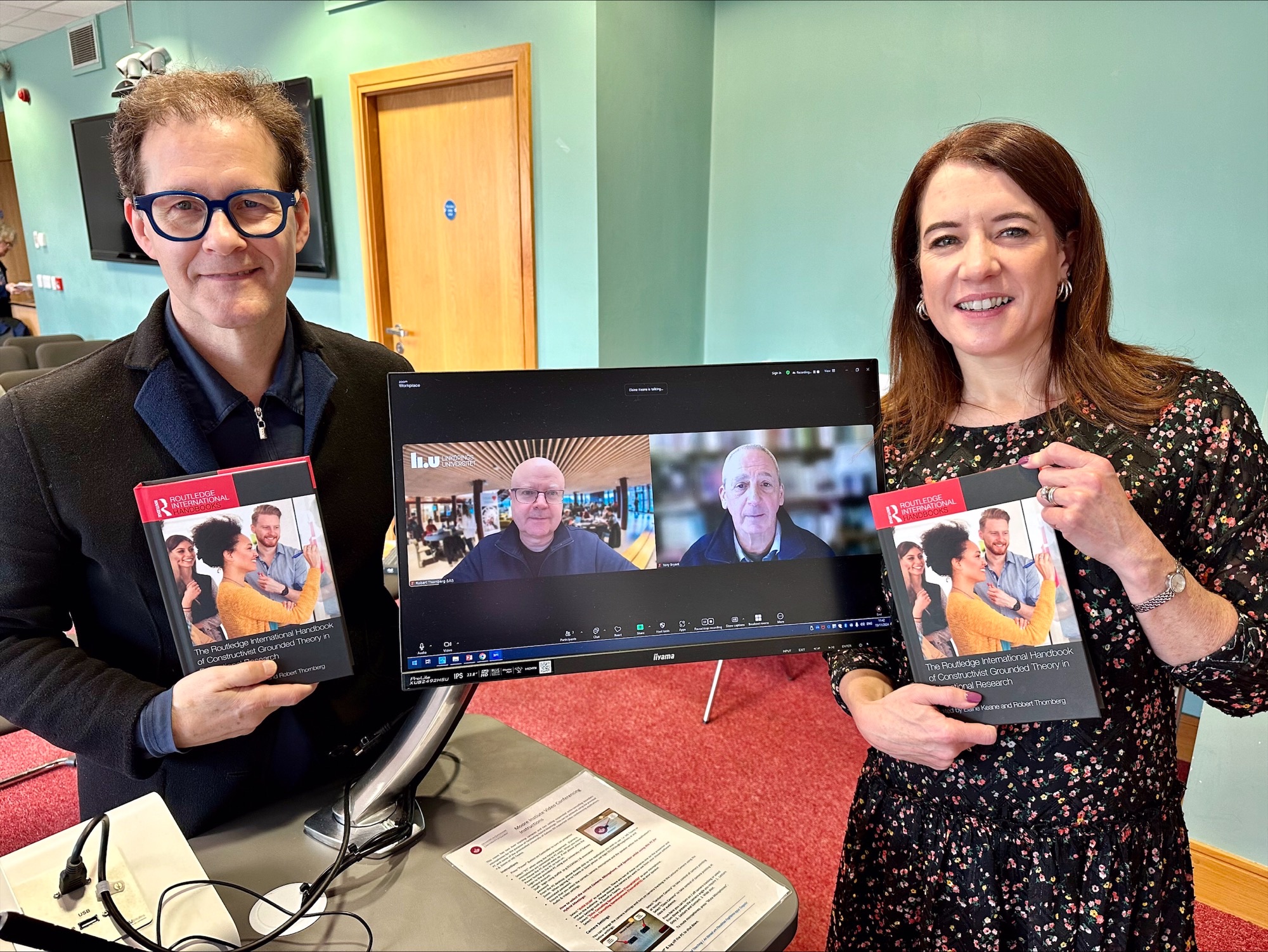 Prof Elaine Keane Book, Prof Dan Carey with two guest speakers' images on computer screen