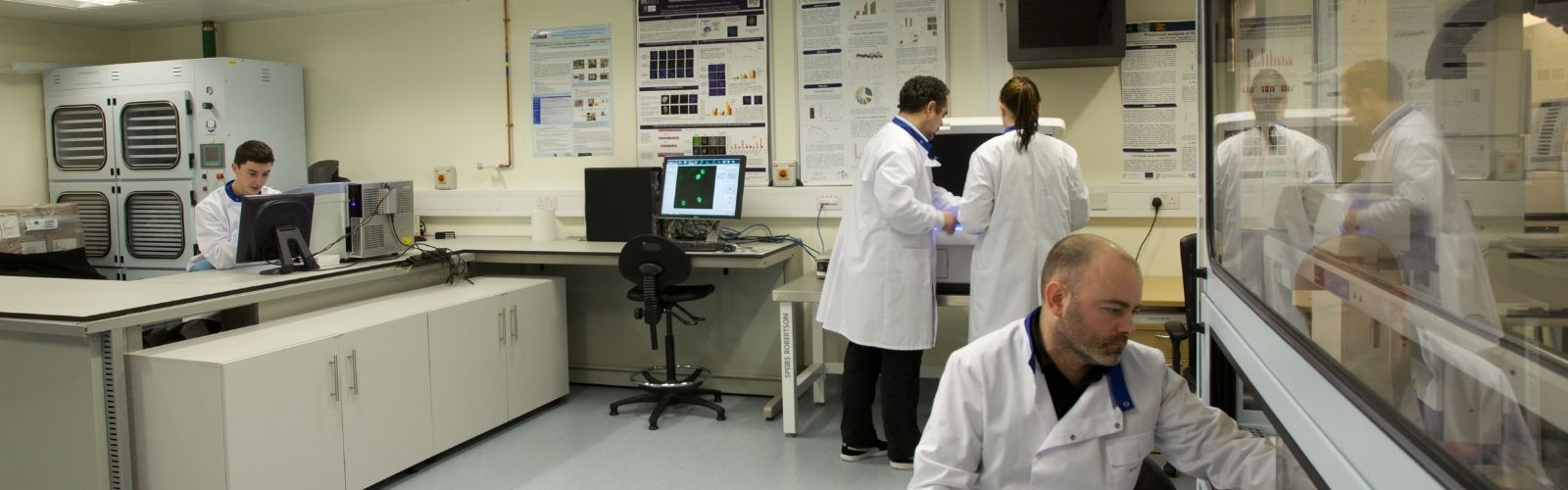 A laboratory with four people in labcoats working with equipment